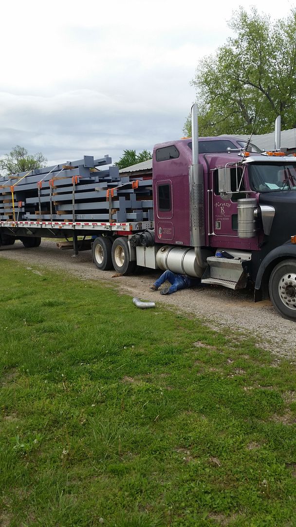 purple flatbed trailer loaded with metal beams in trucking school with trainer fixing exhaust leak purple flatbed trailer loaded with metal beams in trucking school with trainer fixing exhaust leak